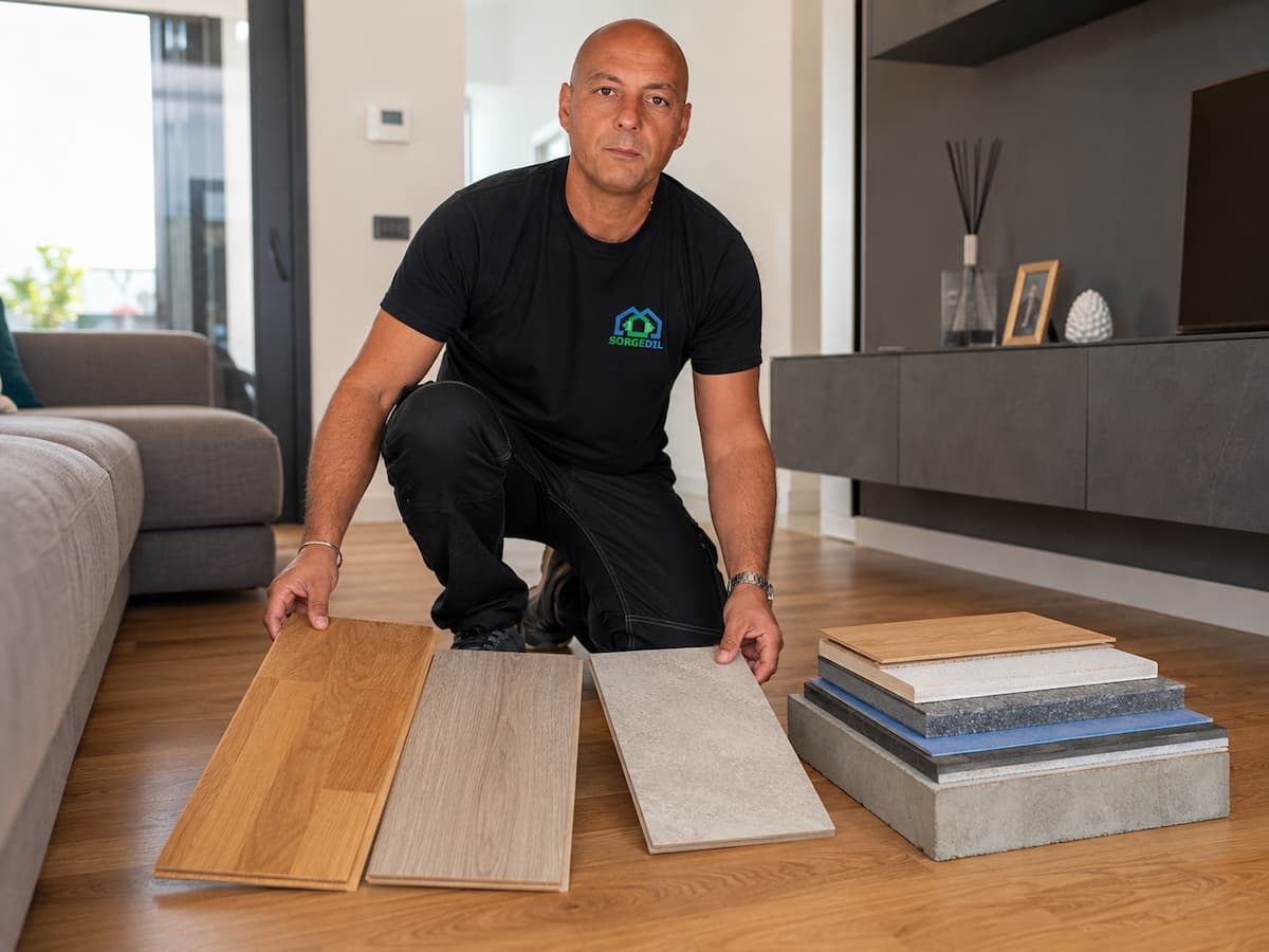 Tecnico Sorgedil mentre confronta campioni di parquet, laminato e ceramica sopra una stratigrafia per l’isolamento acustico del pavimento